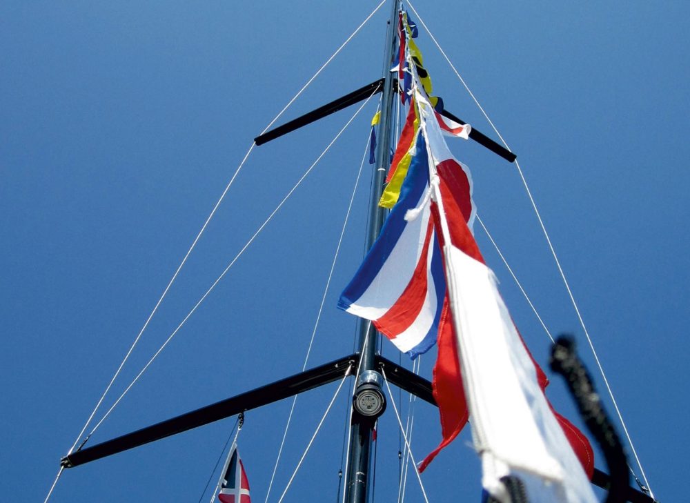 Signalflaggen die man auch für eine Regatta am Startschiff verwenden kann sind an einer Segelyacht zu sehen
